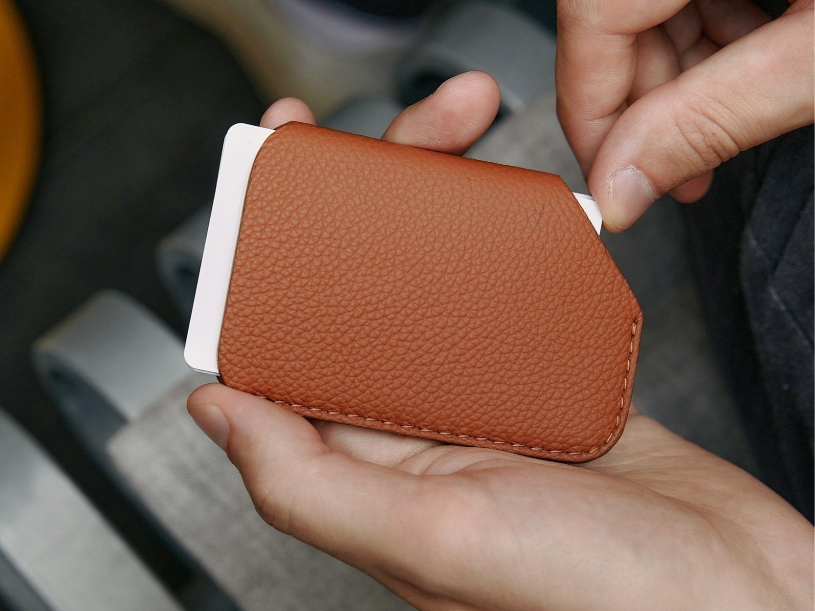 Participant holding a finished custom leather cardholder crafted during team offsite