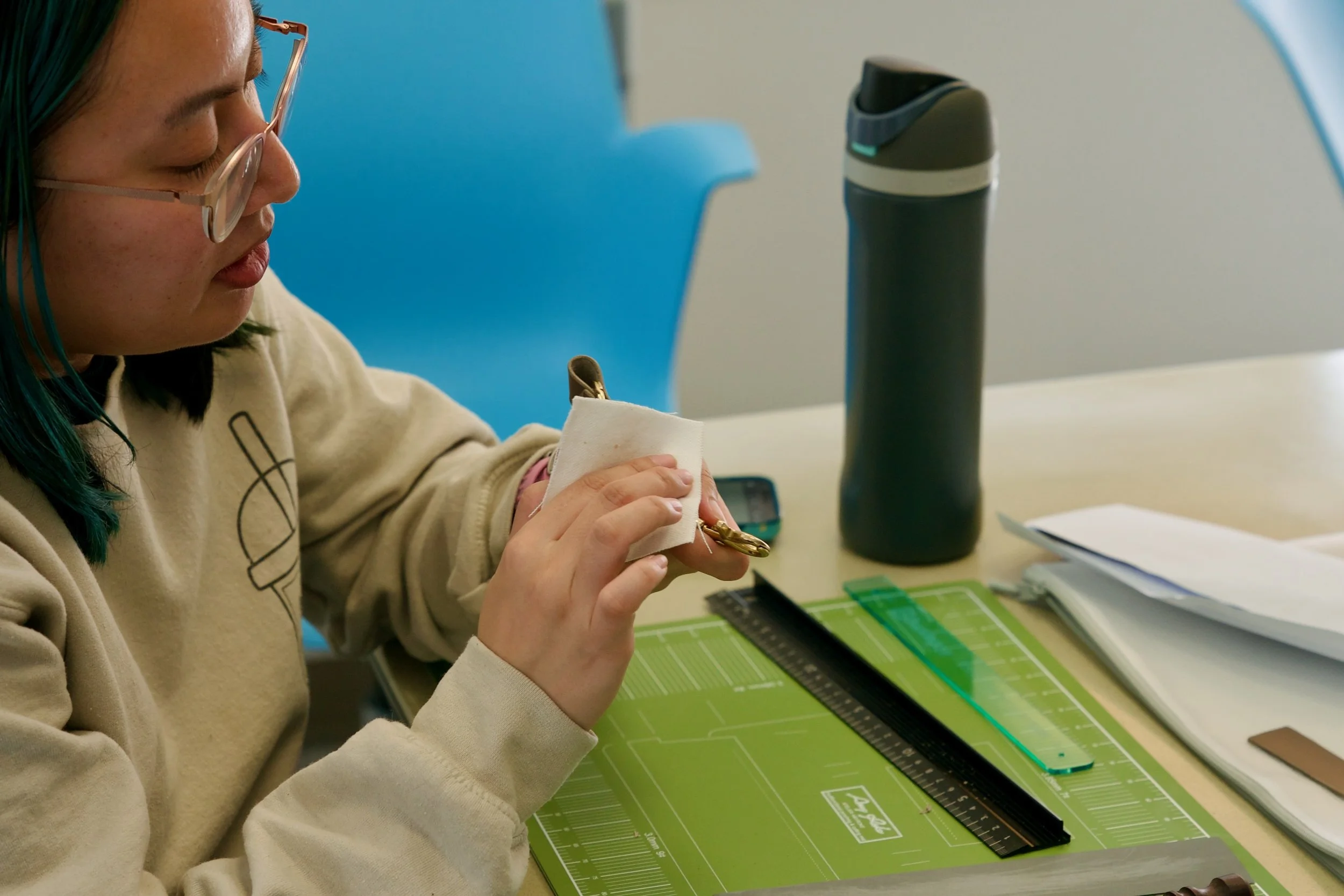 Participant crafting a leather keychain during a live virtual corporate craft event.