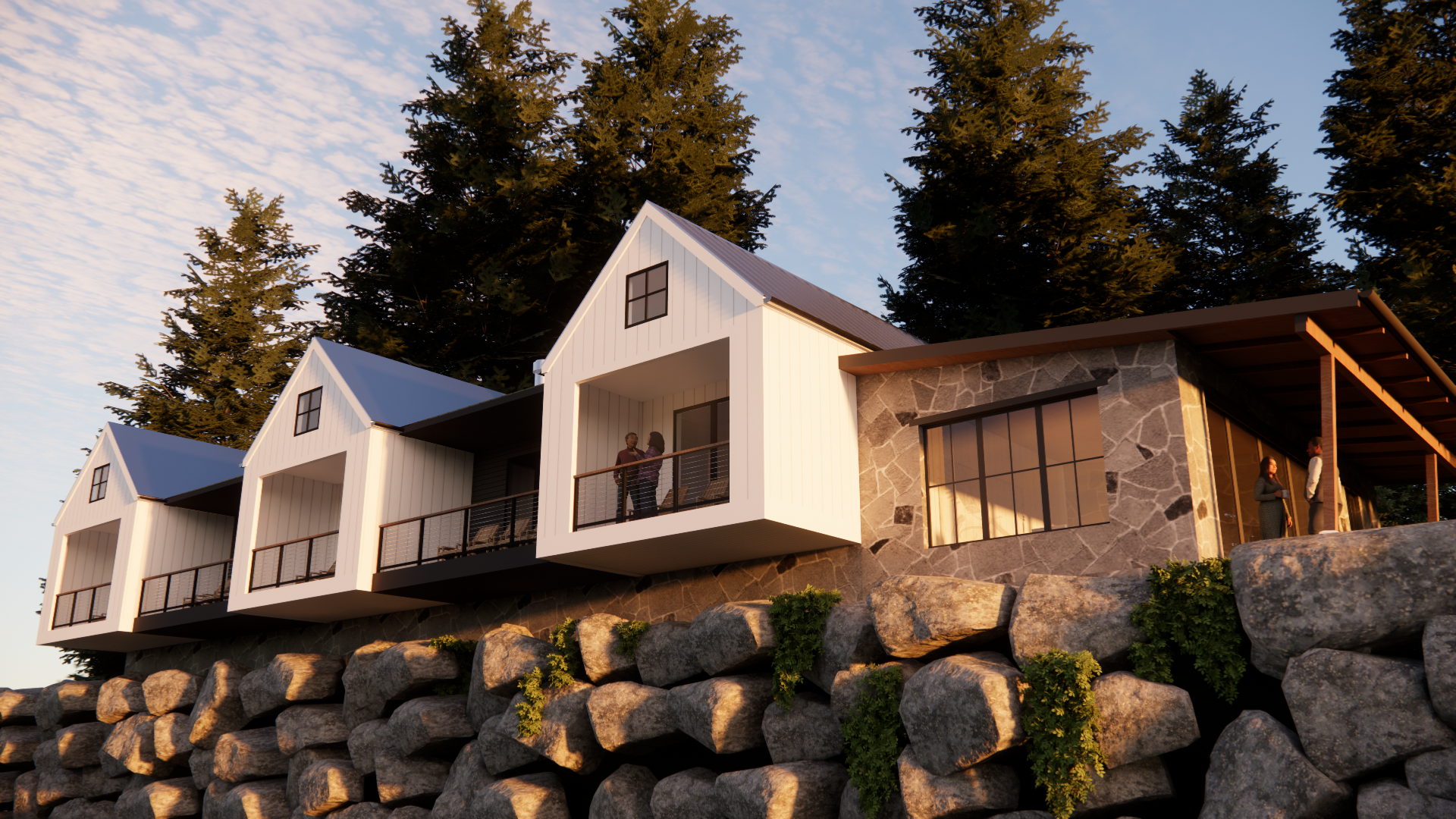 Modern houses built on a rocky slope with large rocks and greenery in the foreground, surrounded by tall trees, during sunset.