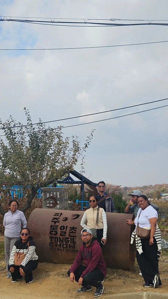 Private tour for Madagascar visitors at Tongilchon, cultural and historical Korean village, tourists exploring local architecture and nature, realistic and detailed travel image