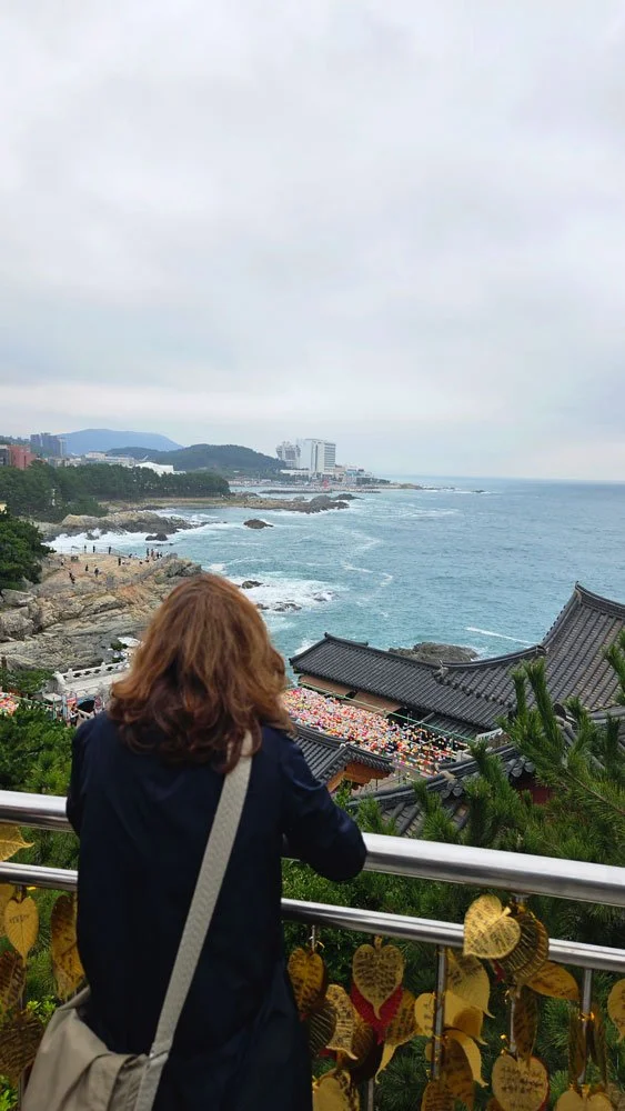 Spanish visitors on a customized private tour exploring Haedong Yonggungsa in Busan, a unique seaside Buddhist temple with stunning ocean views.
