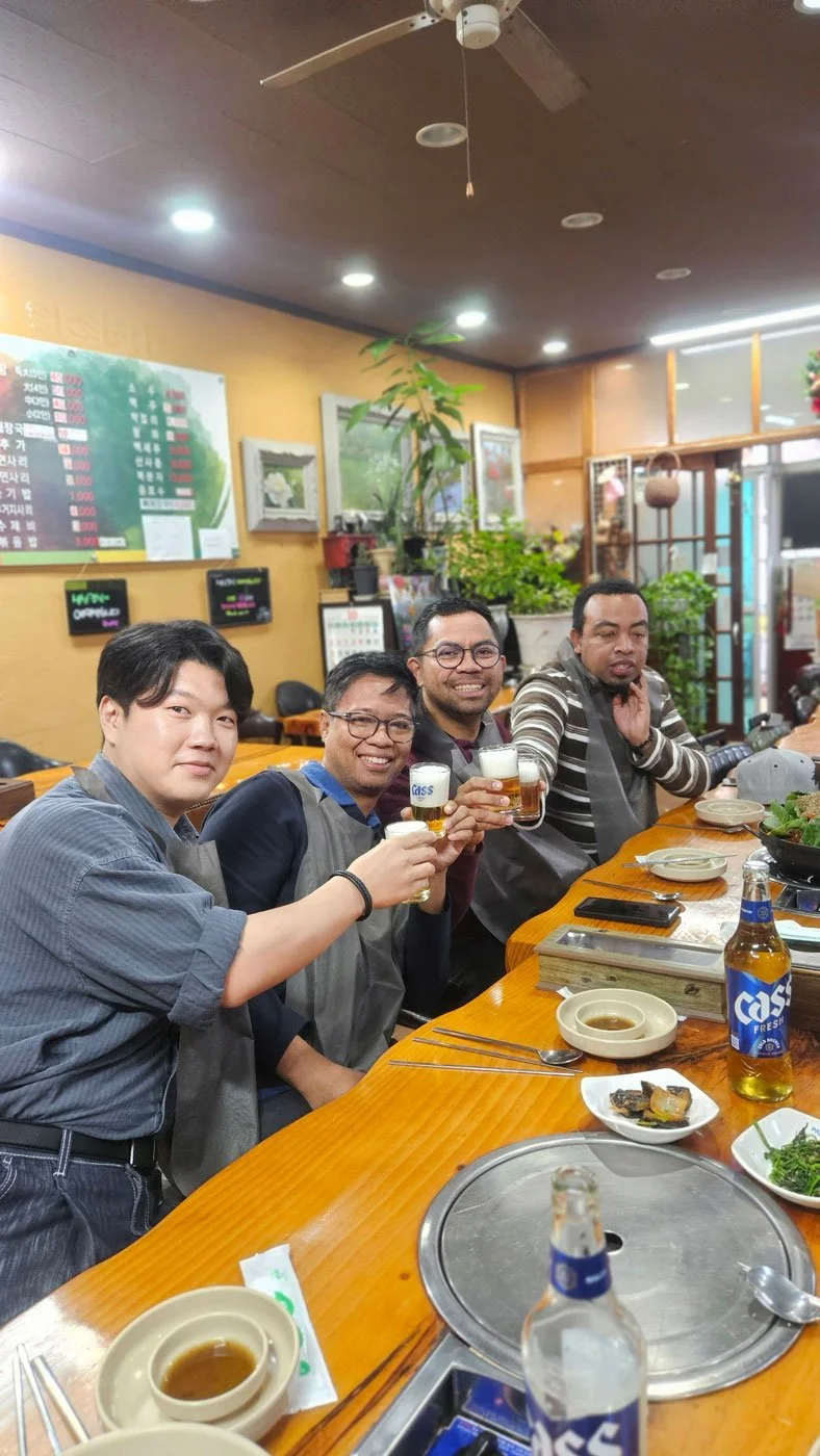 Madagascar travelers on a private tour enjoying traditional Korean gamjatang (pork bone soup), steaming hot, vibrant Korean restaurant setting, authentic cuisine experience, high-resolution food photography with cultural context