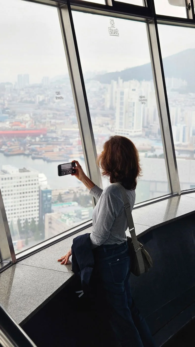 Spanish tourists on a private customized city tour enjoying panoramic views of Busan from Busan Tower, capturing Korea’s modern skyline.