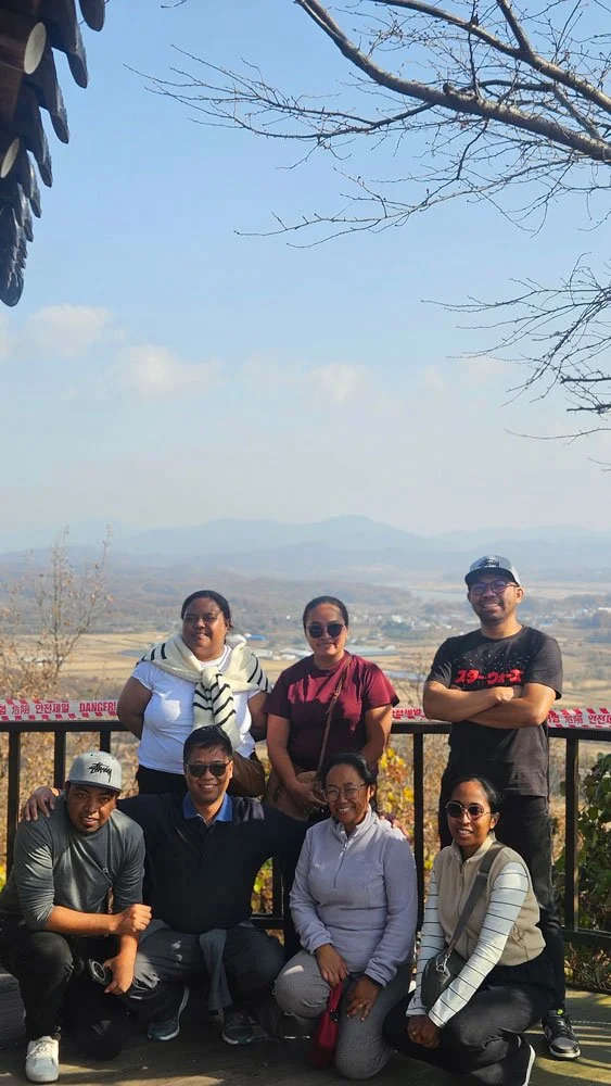 Madagascar travelers on a private tour at Dora Observatory, panoramic views of mountains and cityscape, clear sky, scenic travel photography, high-resolution realistic style