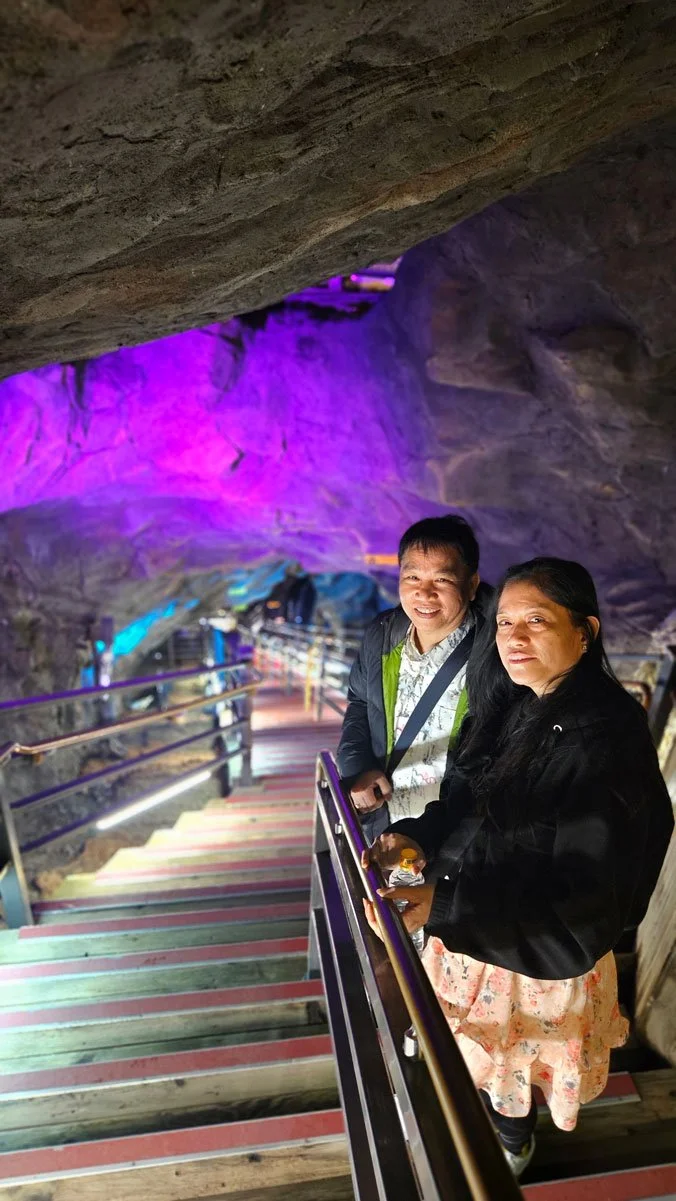 Private tour guests from the Philippines viewing the colorful light displays inside Gwangmyeong Cave.