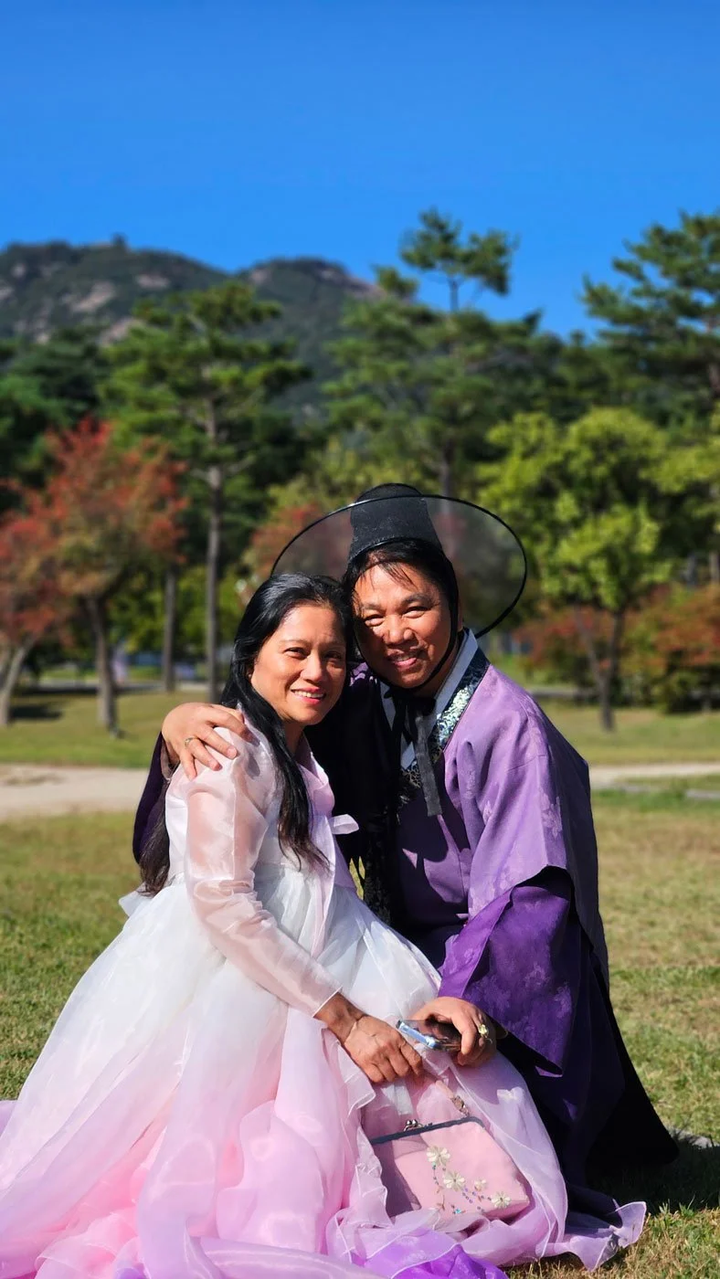 Filipino travelers exploring the royal palace grounds of Gyeongbokgung while dressed in hanbok.