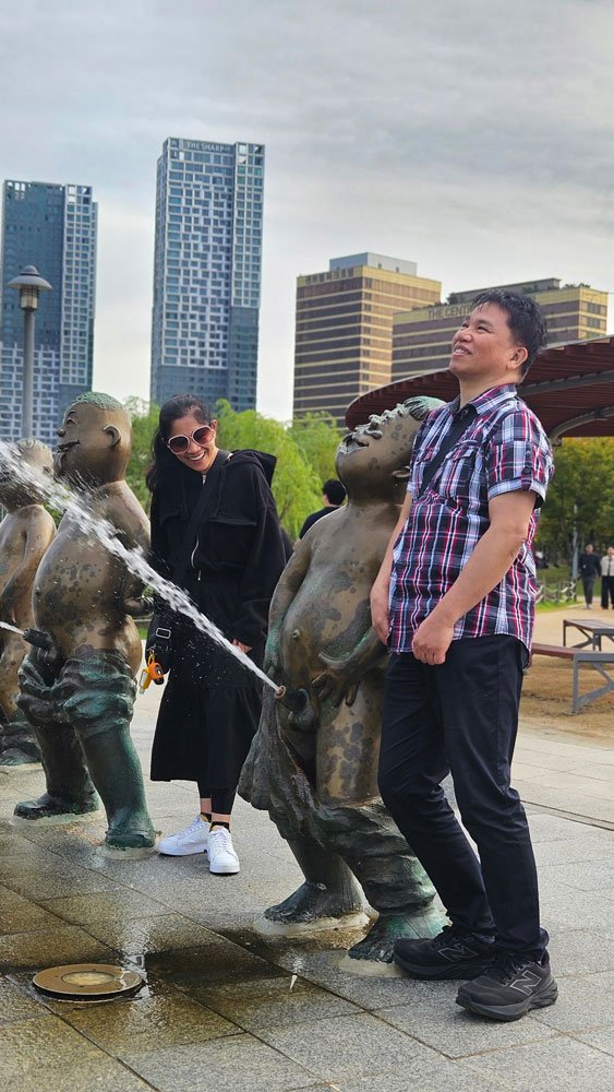 Filipino tourists taking photos along the canal pathways of Songdo Central Park, Incheon Korea.