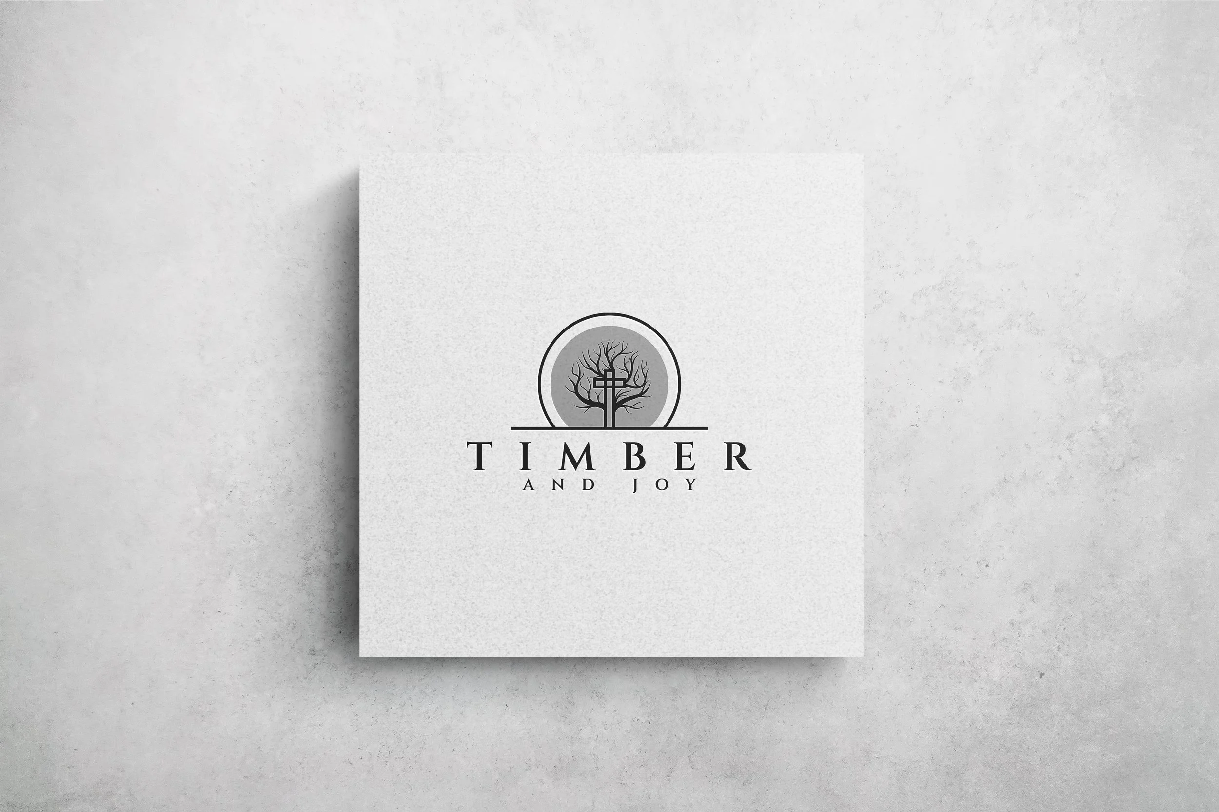 A white square card with a logo of a tree, and the text 'Timber and Joy' underneath on a light gray background.