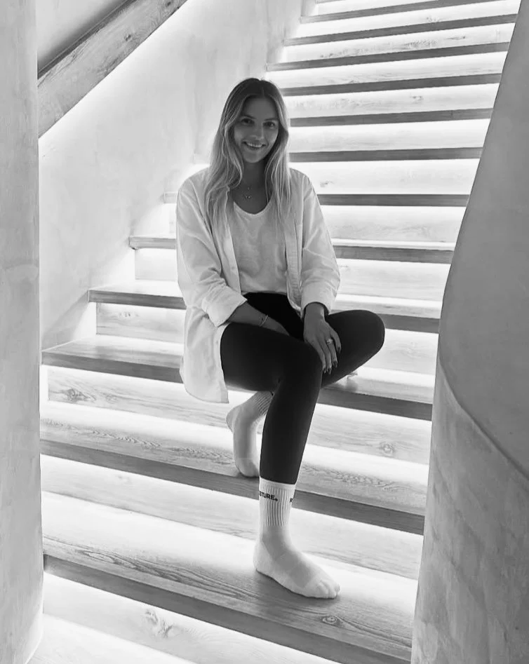Experienced pilates instructor, Addie Browne picture on the pilates studio stairs of Posture Downtown, Dubai.