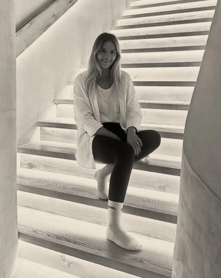 Experienced pilates instructor, Addie Browne picture on the pilates studio stairs of Posture Downtown, Dubai.