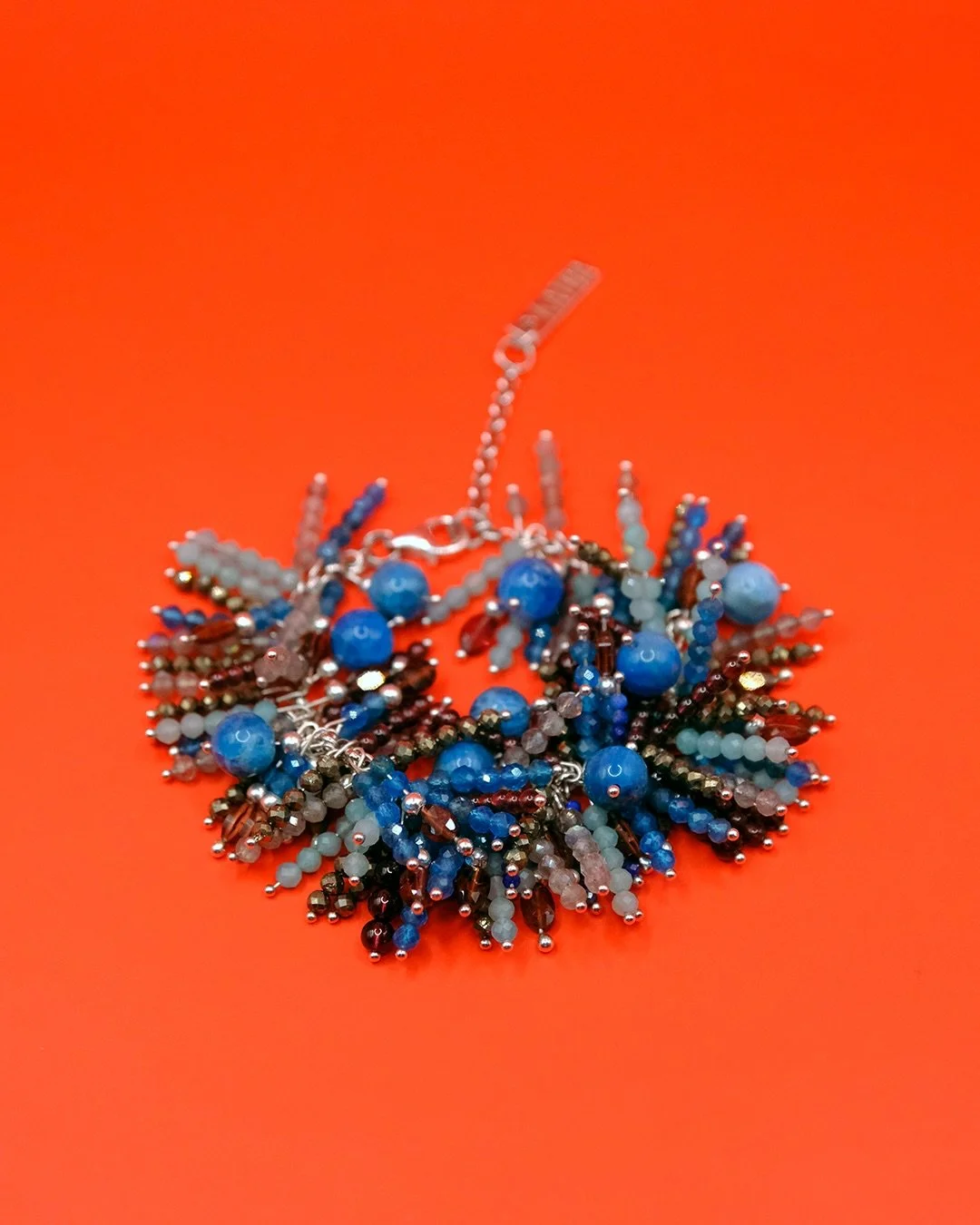 The Electric Fuzz bracelet features so many interesting stones: electric blue apatite, soft light blue amazonite, deep red rhodolite rounded garnet and faceted garnet beads, and labradorite flashing with blue, as well as very sparkly pyrite.

Availab