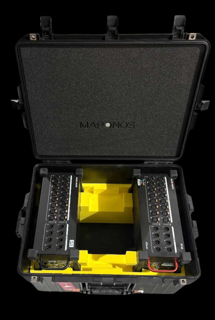 A black hard carrying case with foam padding, open to reveal two audio power amplifiers with multiple input and output jacks stored inside, with a yellow foam insert in the middle.
