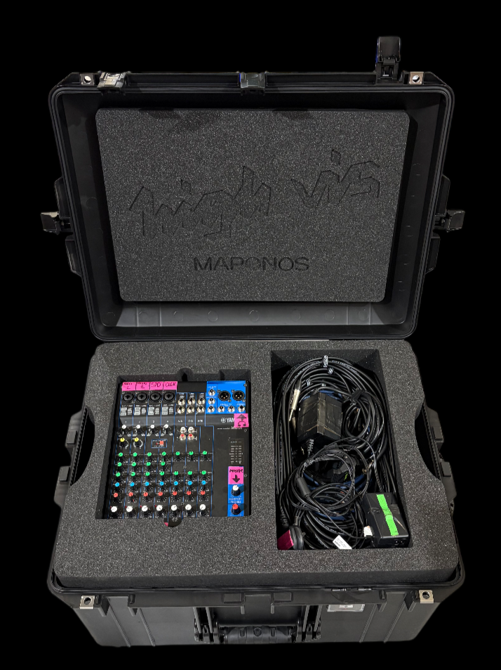 Open black hard case with foam interior containing a colorful audio mixer and black cables.