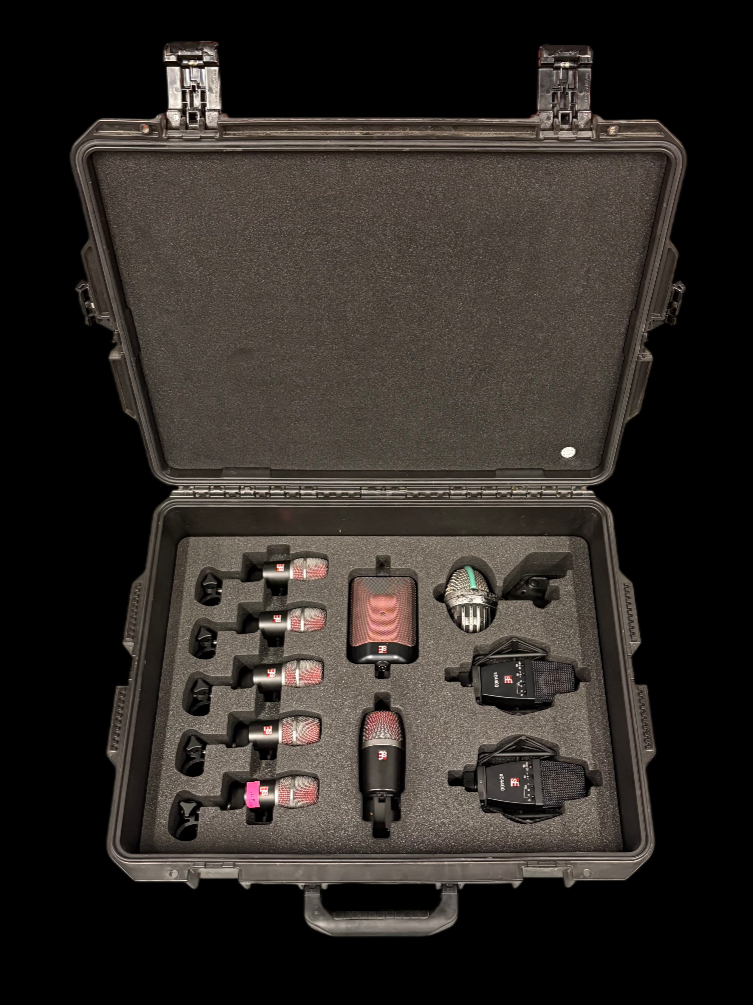 Open carrying case with multiple wireless microphone transmitters, receivers, and accessories, all organized with foam padding.