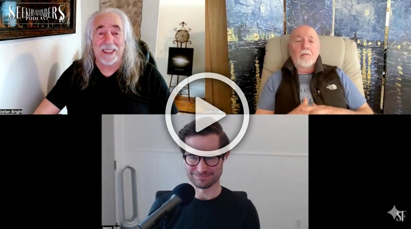 Three men are participating in a video call. The man on the top left has long gray hair and a beard, smiling and wearing a black shirt. The man on the top right is bald, with a gray beard, and is sitting in front of a cityscape wall art, wearing a gray T-shirt and a black vest. The man at the bottom is wearing glasses, smiling, and sitting in front of a plain white wall with a microphone in front of him.