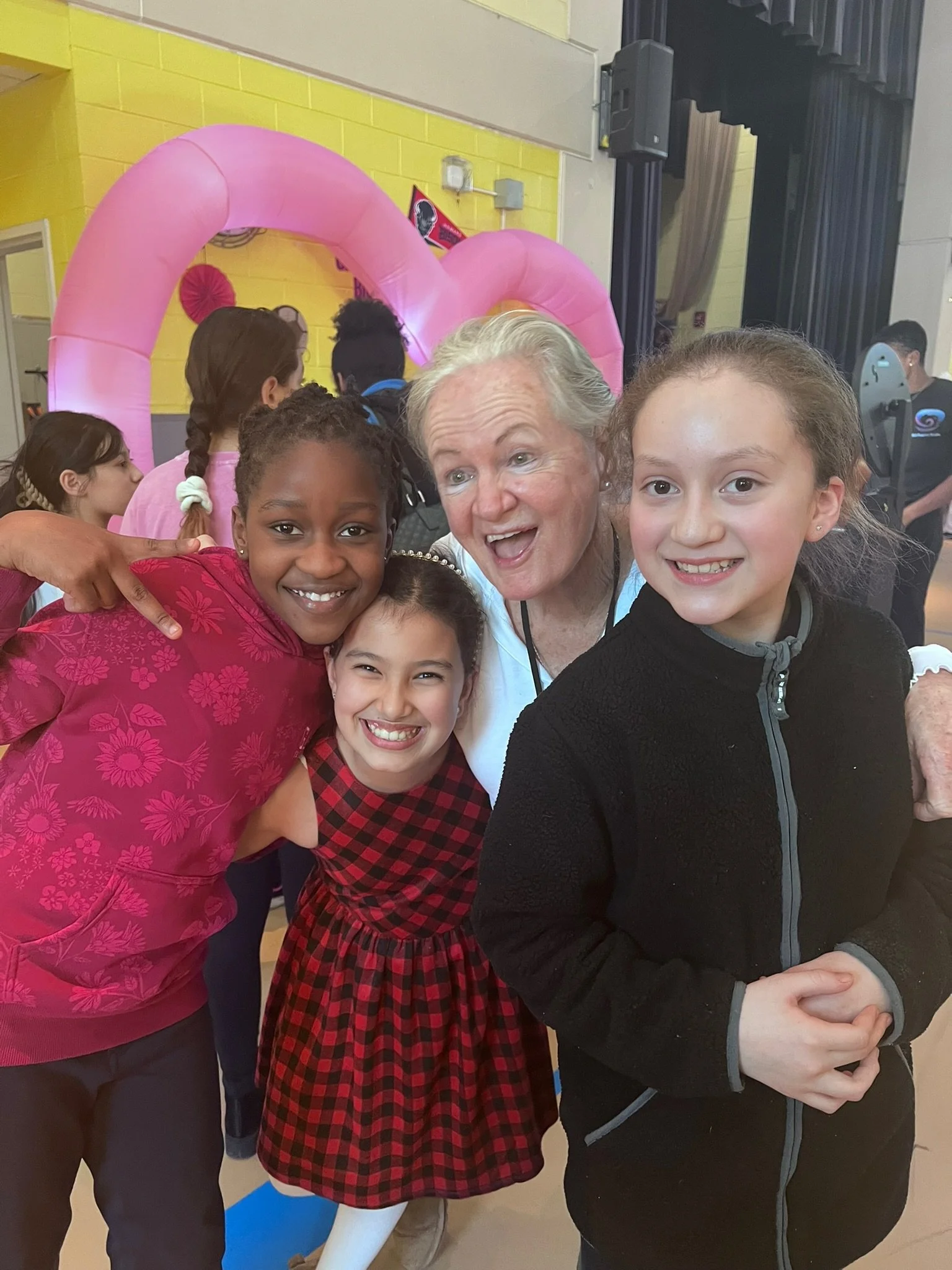 A Barnard teacher and three students smiling emphatically.