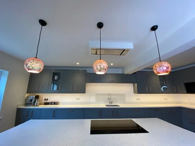Modern kitchen with hanging pendant lights and blue cabinets
