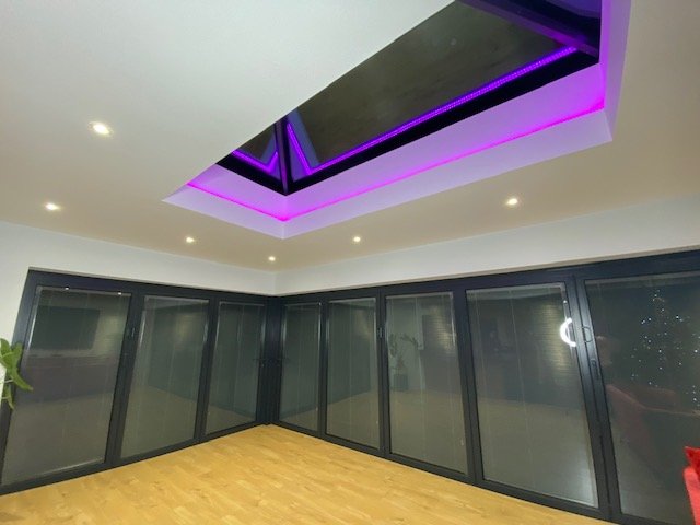Modern room with large glass doors and purple LED ceiling lights