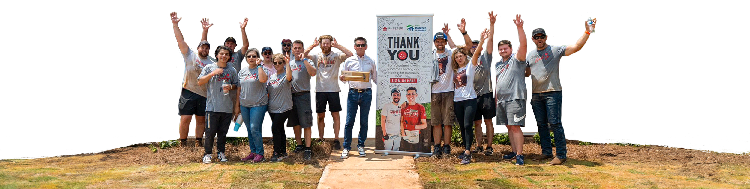 Supreme Lending volunteers cheer beside a Thank You banner at a Habitat for Humanity build site