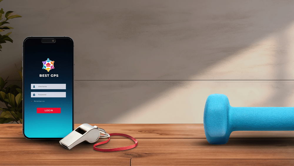 A smartphone showing the BEST GPS login screen on a wooden desk beside a whistle