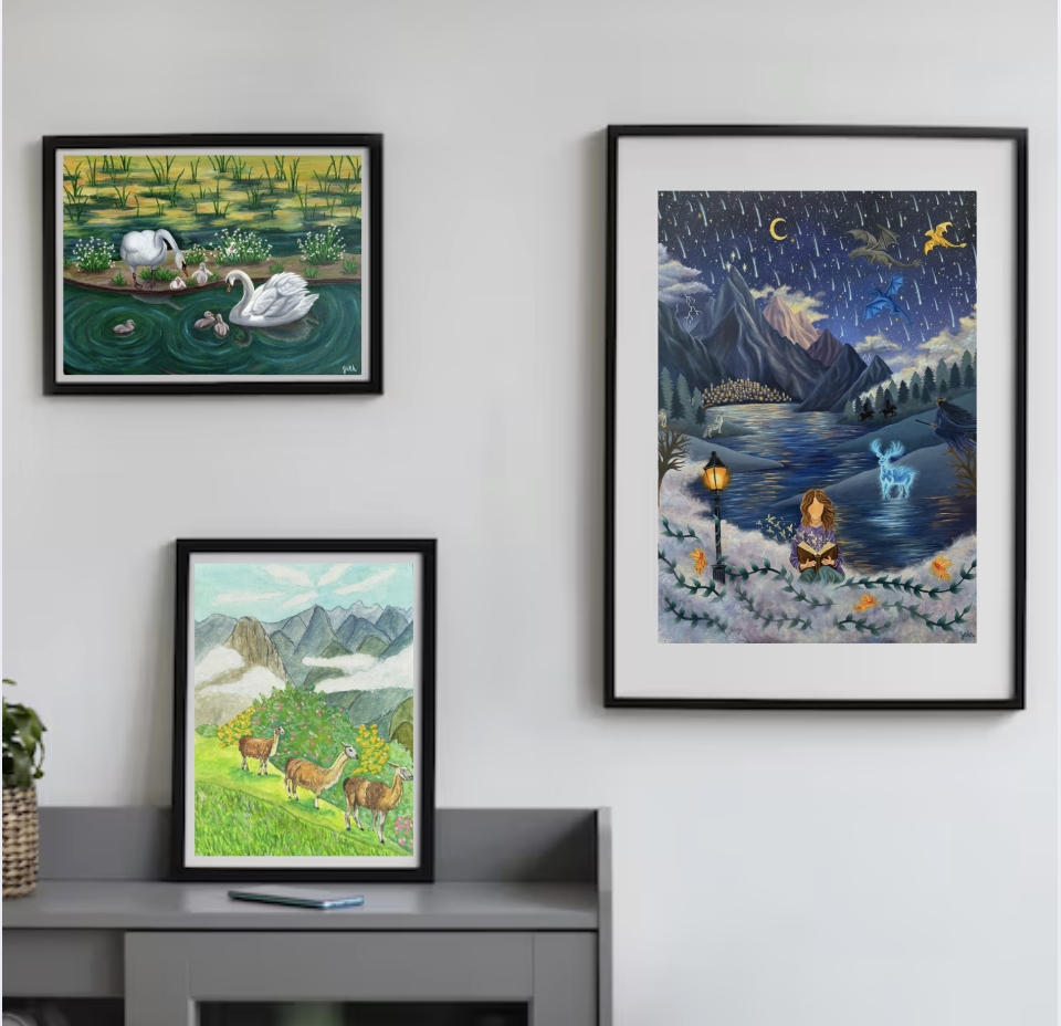 Three framed paintings on a wall and a laptop on a gray shelf. The top left painting features a swan swimming with ducklings in a pond with green plants. The bottom left painting depicts three llamas walking in a mountainous area with green grass and blooming flowers. The right painting is a fantasy scene with mountains, a river, flying dragons, a girl reading under a street lamp, and a starry night sky.