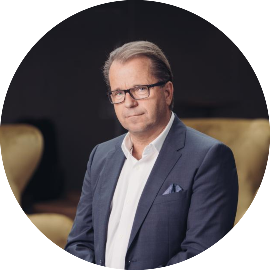 Black and white photo of a middle-aged man wearing glasses, a suit jacket, and a collared shirt, smiling confidently.