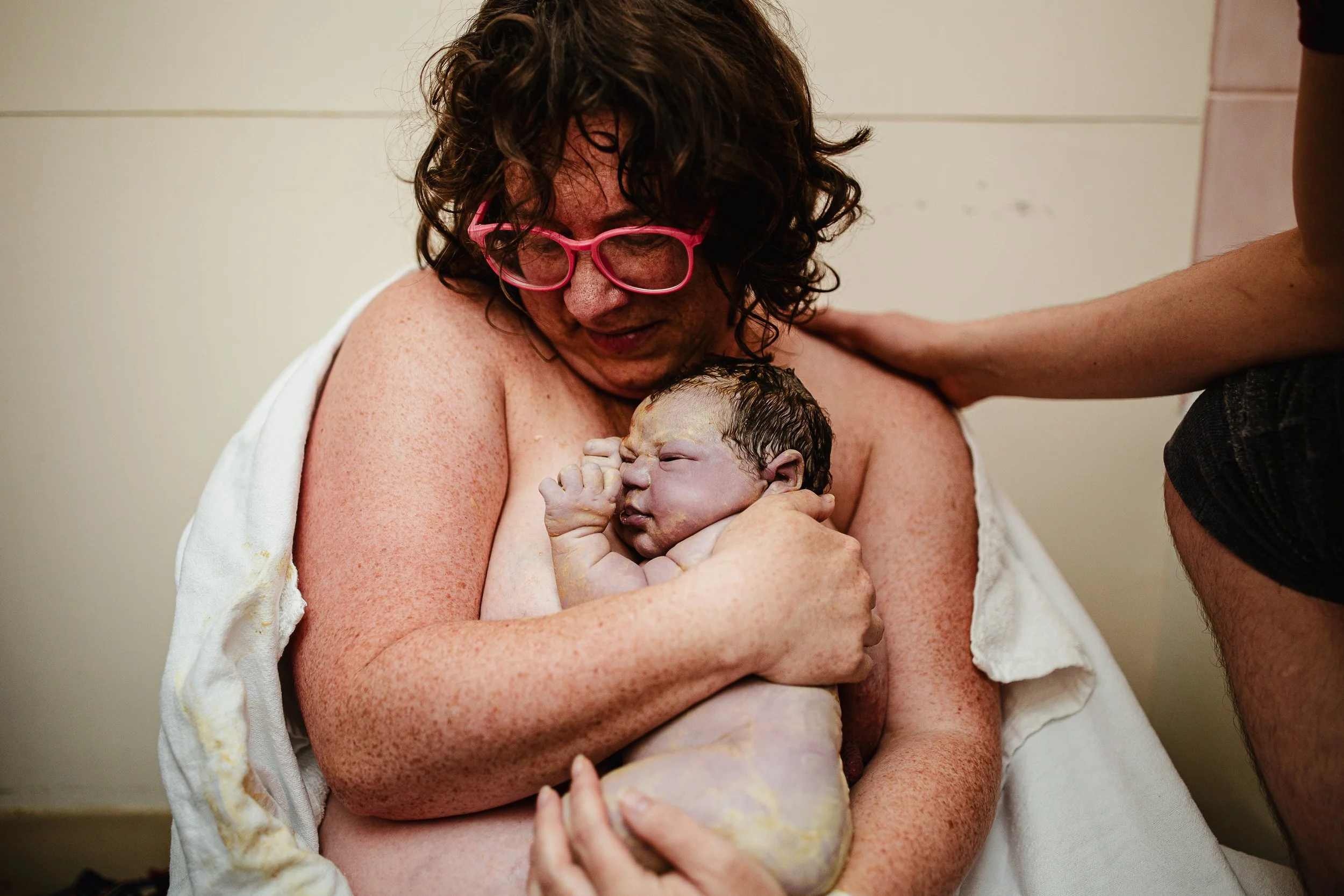 Randi Armstrong, Co-Founder of The Nurturing Company, holding her second-born skin-to-skin immediately after birth. Photo by Brianna Trammell, doula and photographer in Grand Rapids, Michigan.