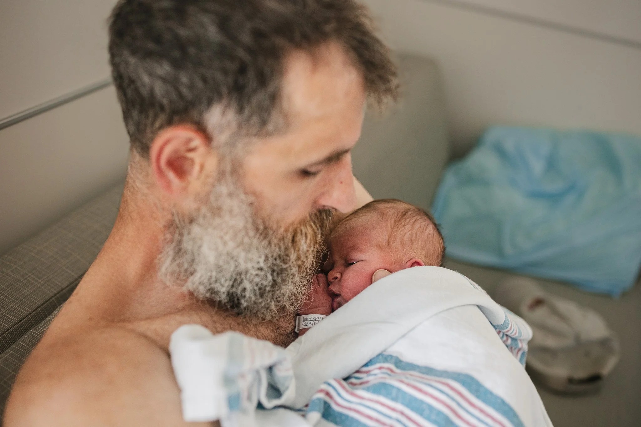 Man holds his newborn baby skin-to-skin.