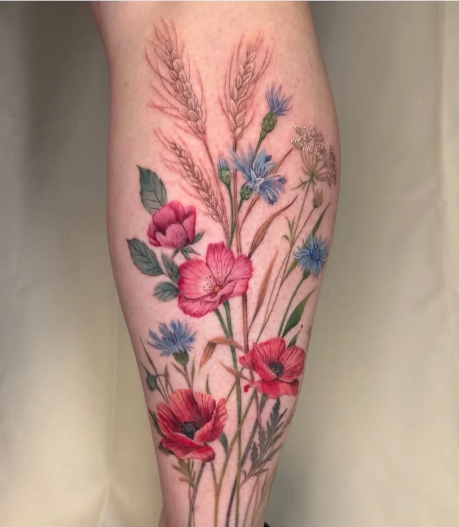 Colour wildflower calf tattoo of red poppies, blue cornflowers and wheat stems by guest artist Devin Evans