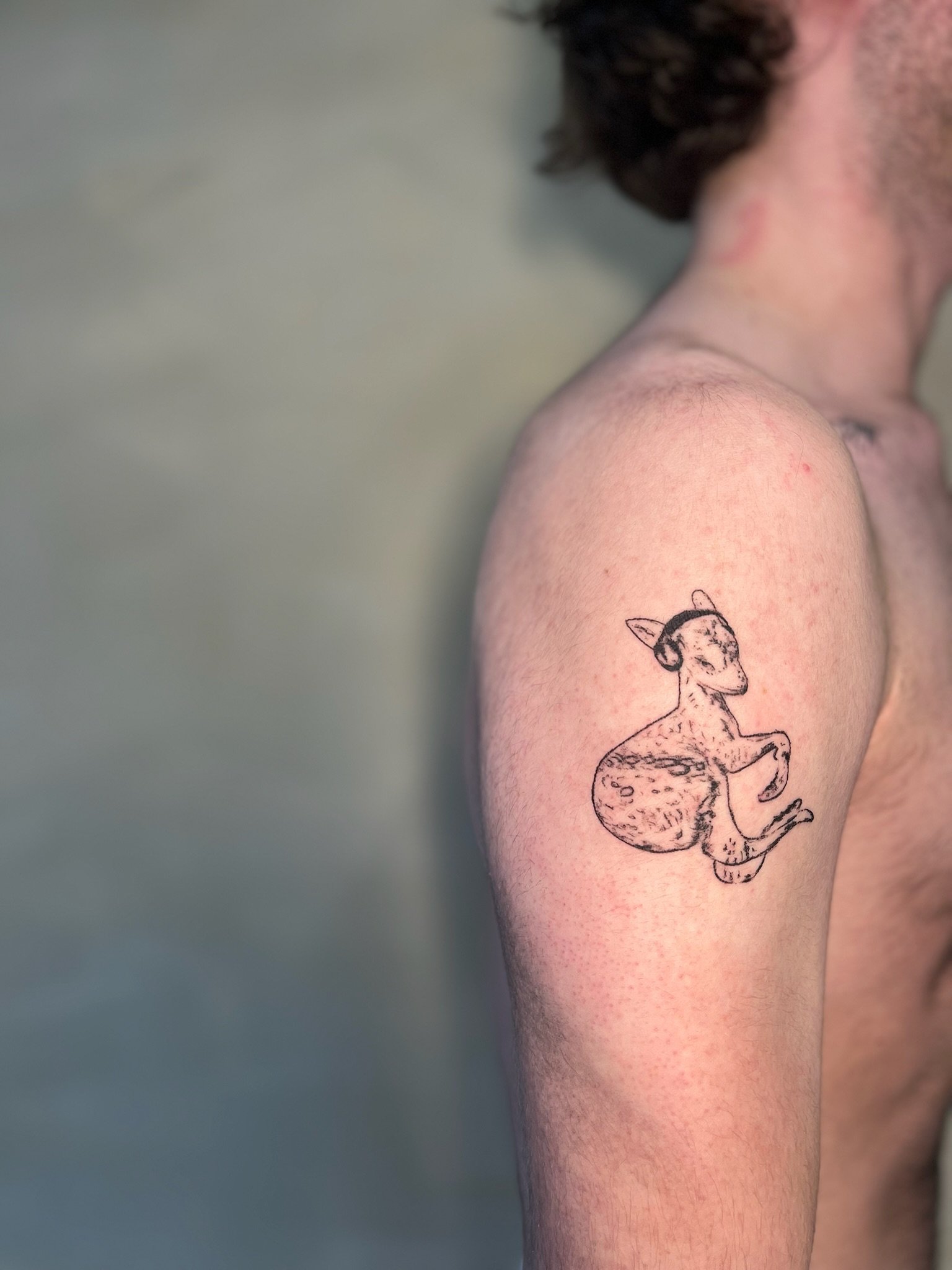 stylised animal figure of a horned goat wearing headphones, Fontaines emblem/logo