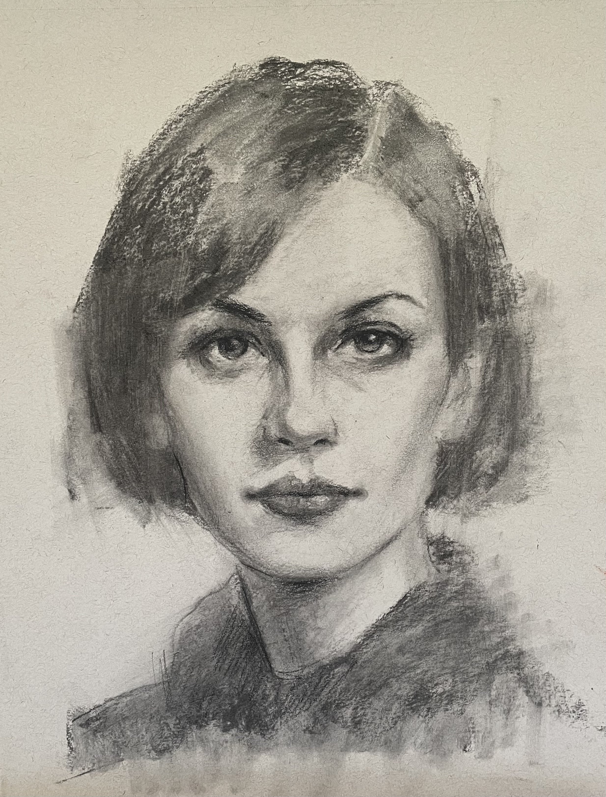 Black and white charcoal sketch of a woman's face with short hair and a serious expression.