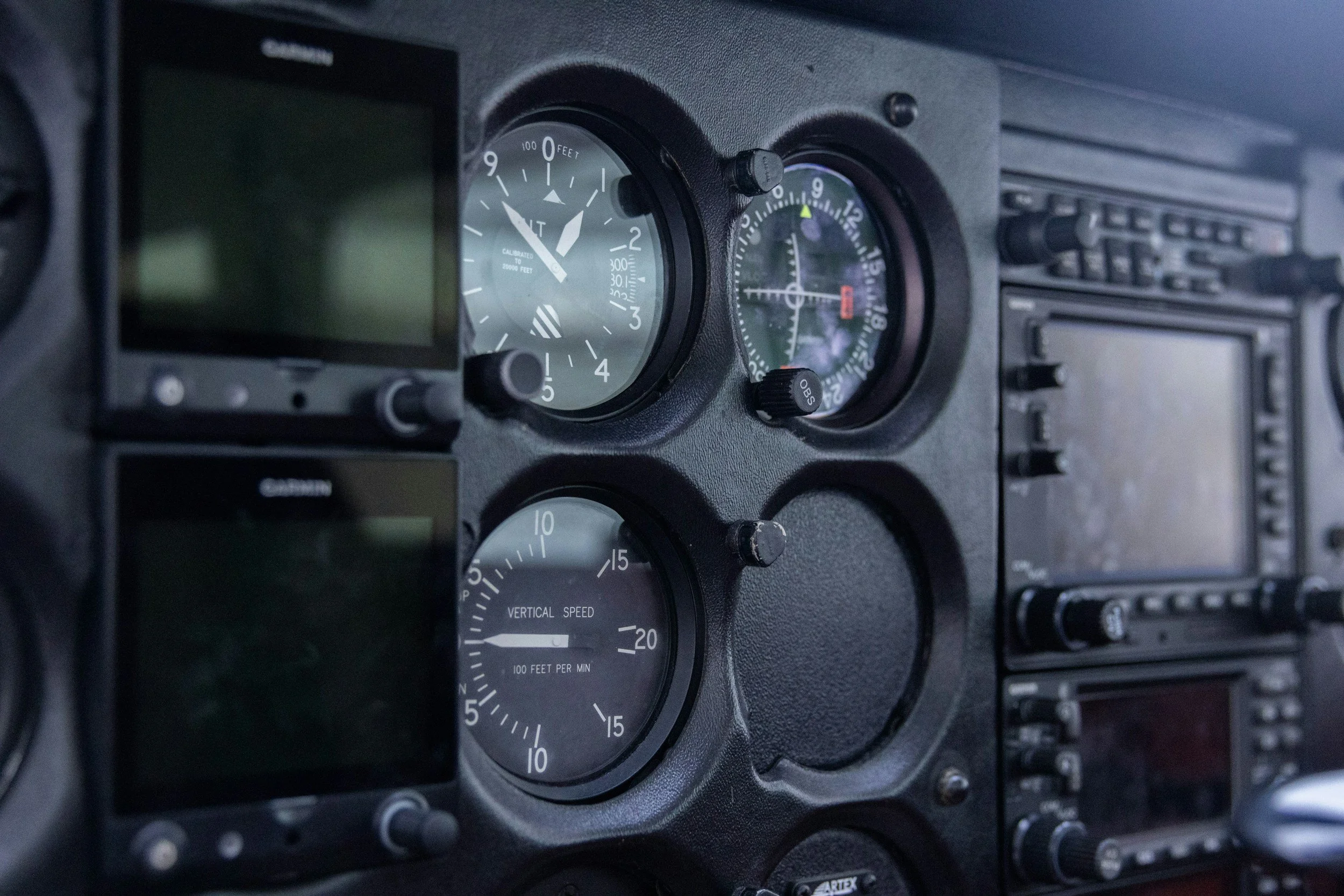 The dashboard of an aircraft cockpit showing various gauges, including an altimeter, a vertical speed indicator, and other flight instruments.