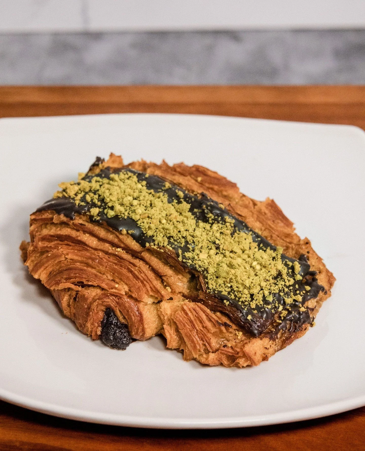 Our Pistachio Chocolate Croissant balances deep cocoa notes with the subtle sweetness of toasted pistachio. Flaky, fragrant, and baked to golden perfection. A pastry that delights the senses from first glance to final bite.