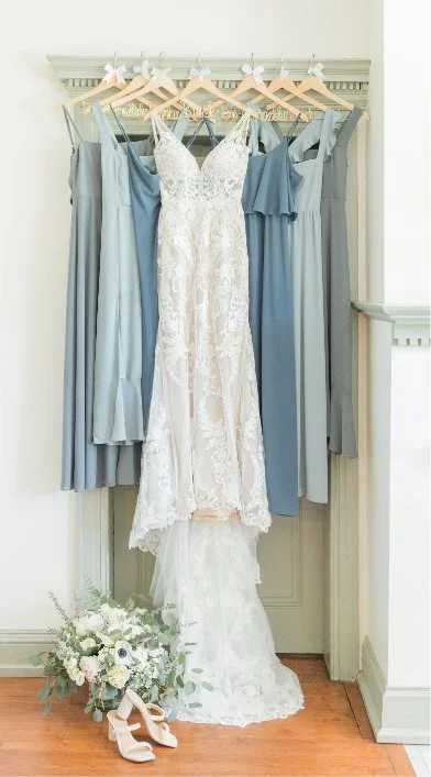 Bridal gowns hanging up in bridal suite in blue tones