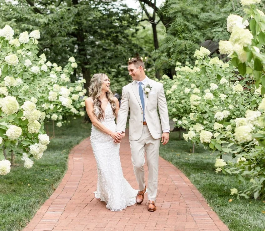 Bridge and Groom walking through hydrangeas