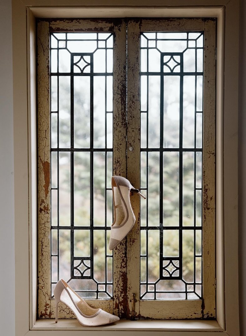 High heels hanging in rustic, historic window