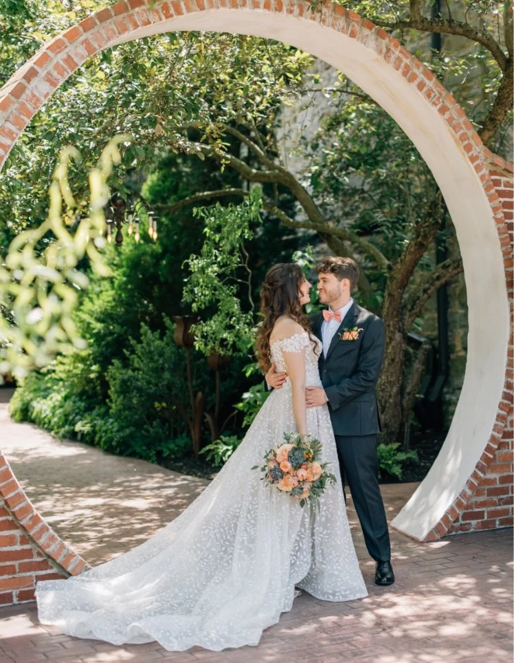 Couple posing under the brick moongate