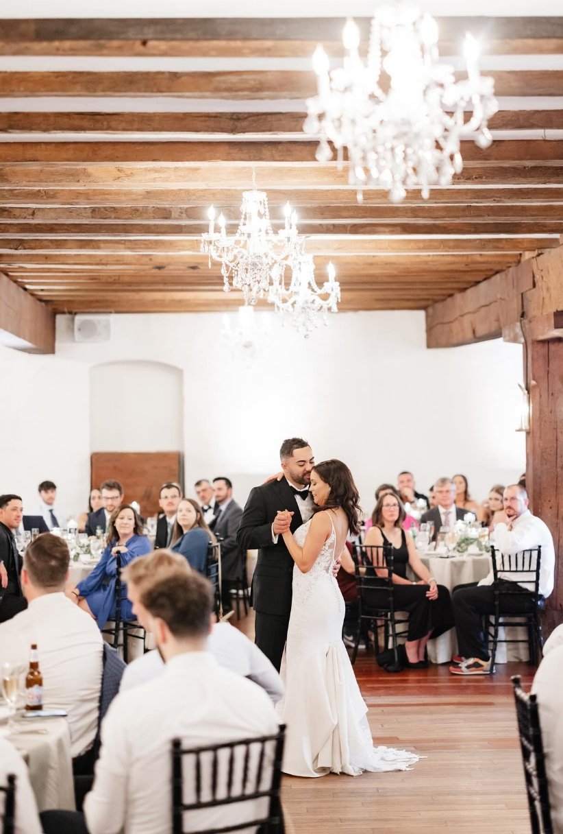 Couple dancing under chandelier inside the old Mill building