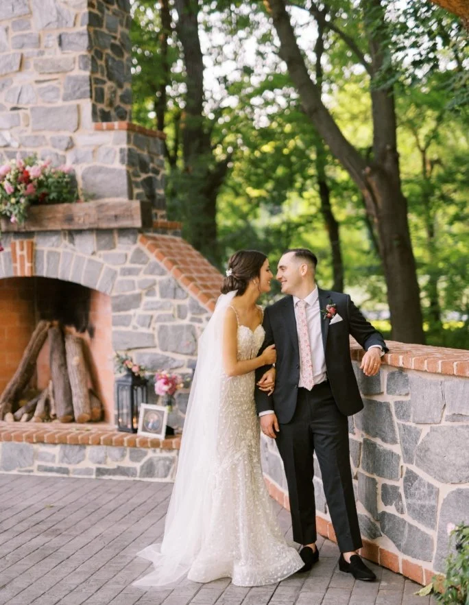 Bride and groom posing on the stone patio