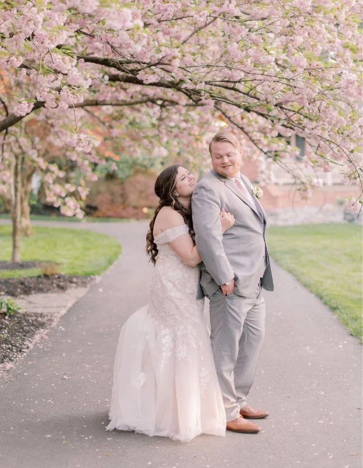 Bride and Groom posing under the cherry blossom trees