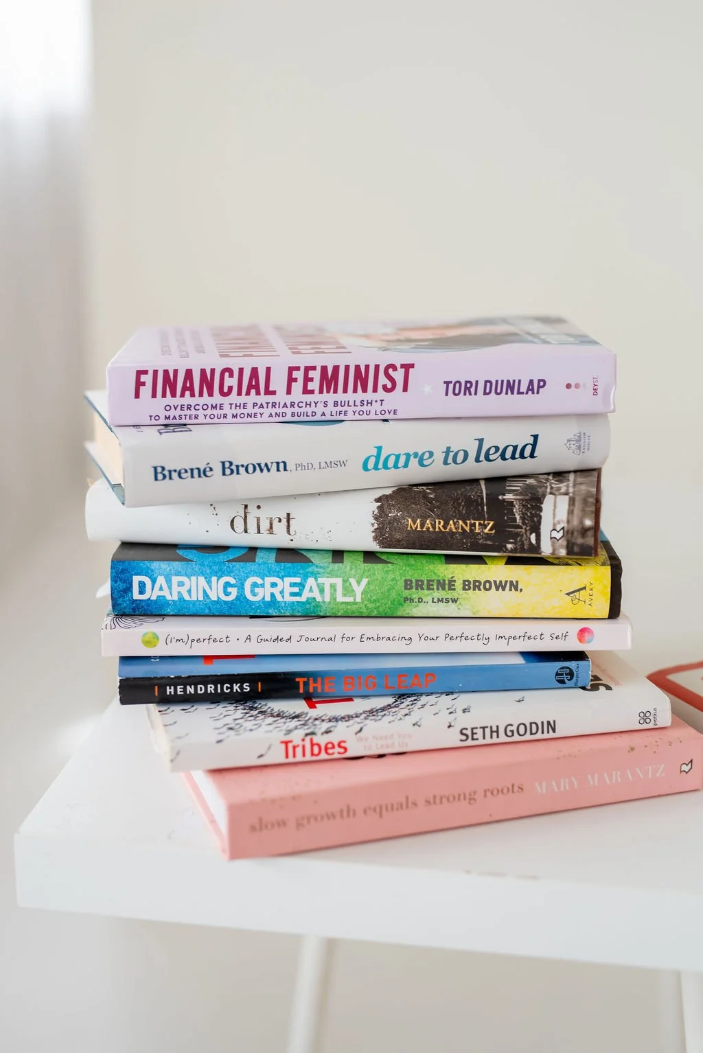 Stack of personal development books including Daring Greatly and Dare to Lead