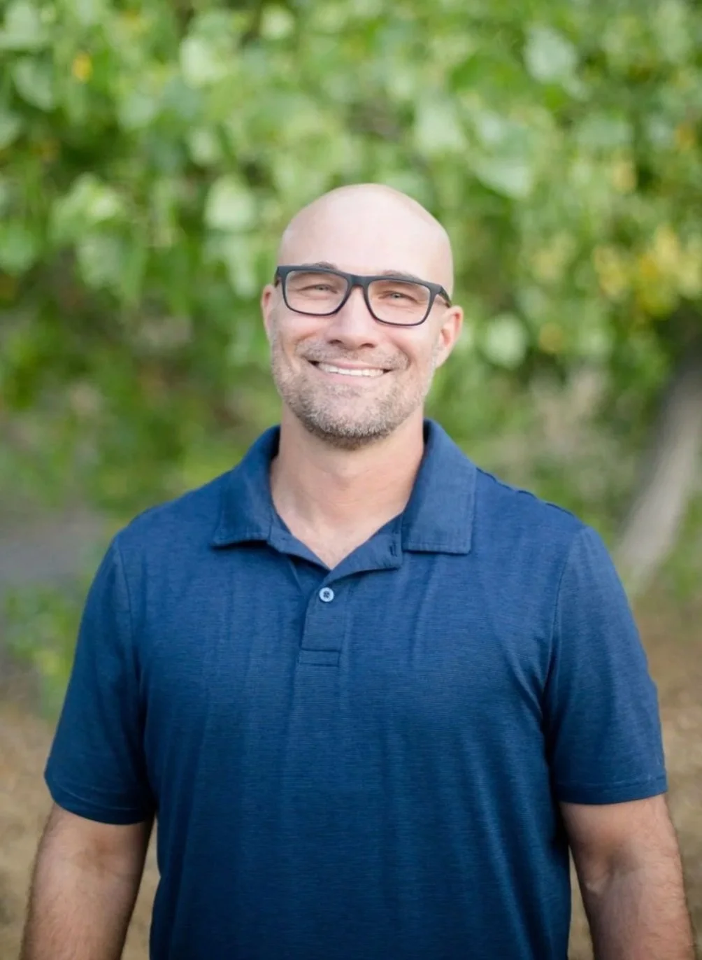 Dave Wilson of Mealer Family Therapy wear a navy blue polo shirt and glasses