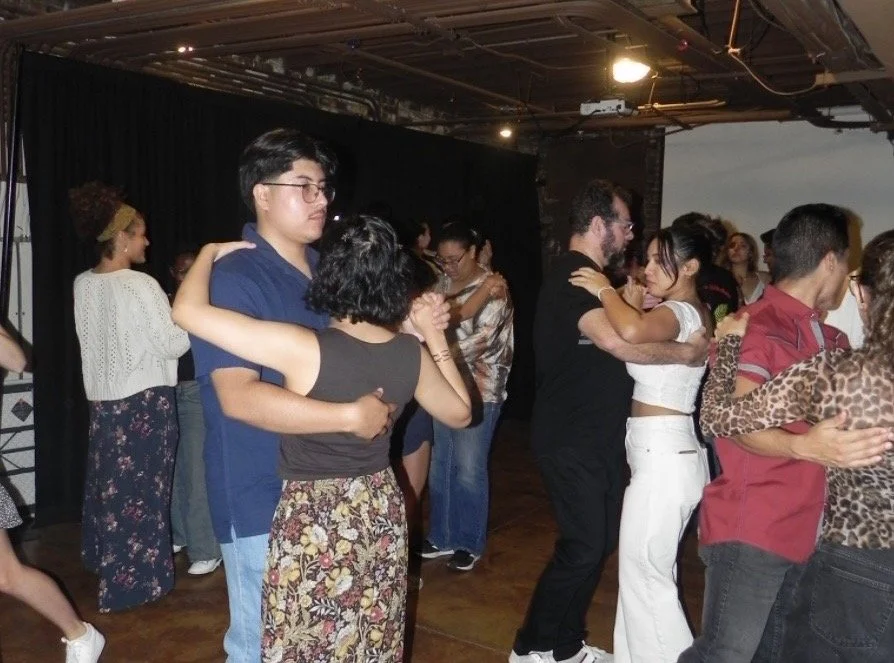 People dancing bachata closely in pairs at a social dance event at Sozos Coffeehouse.