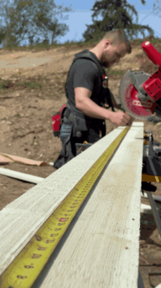 Oakhaven owner Cody using a tape measure to measure siding before cutting on band saw