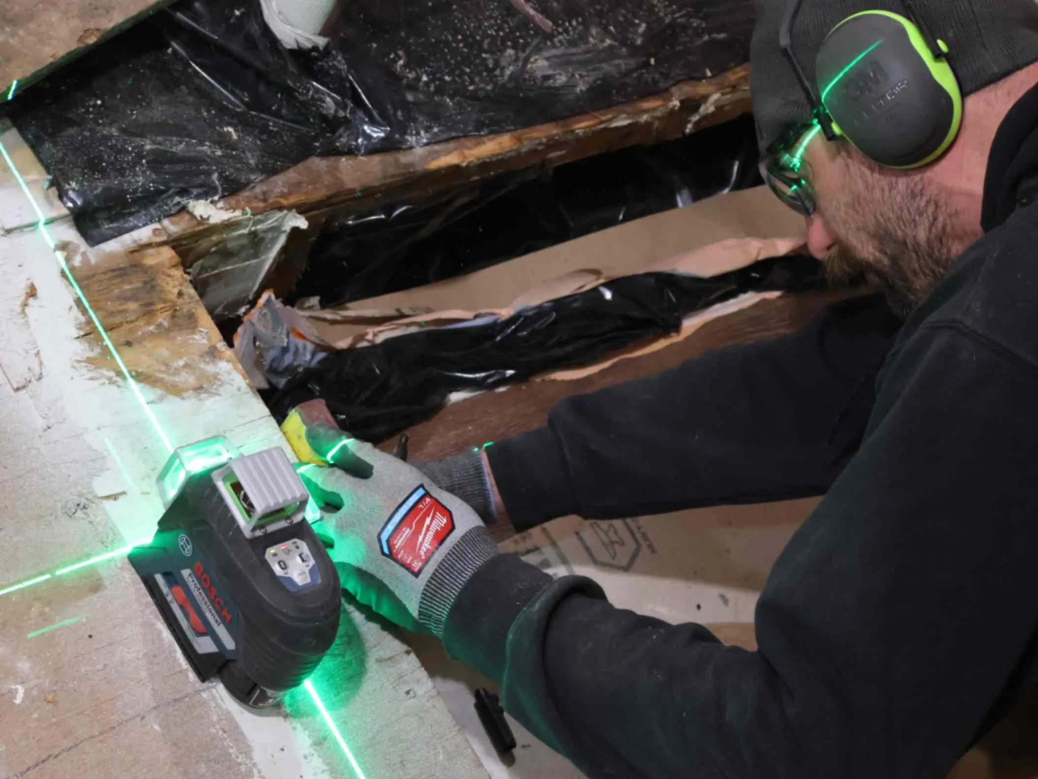 Oakhaven team member using laser level on floor to level