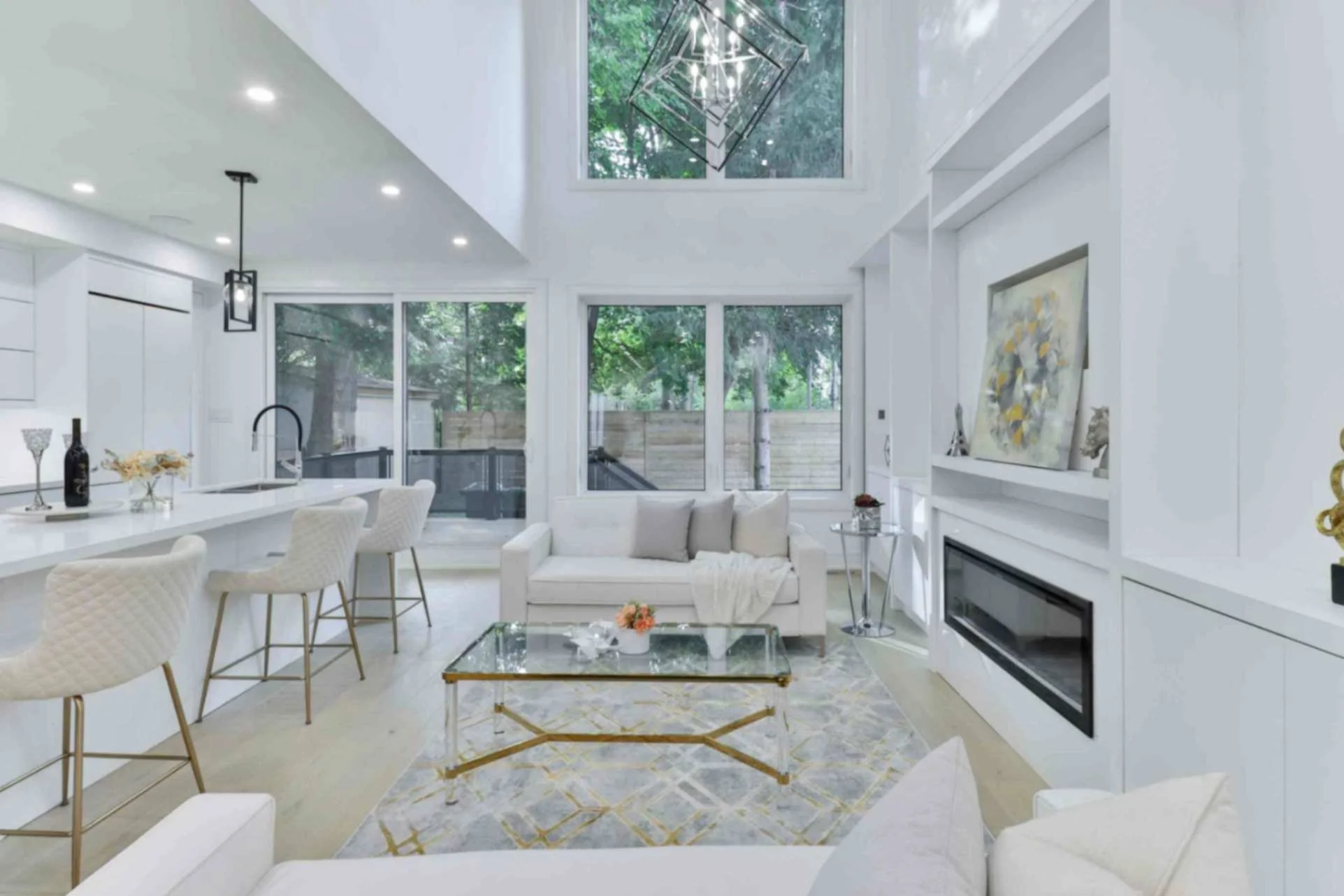 white and gold kitchen and living room with feature fireplace and open concept