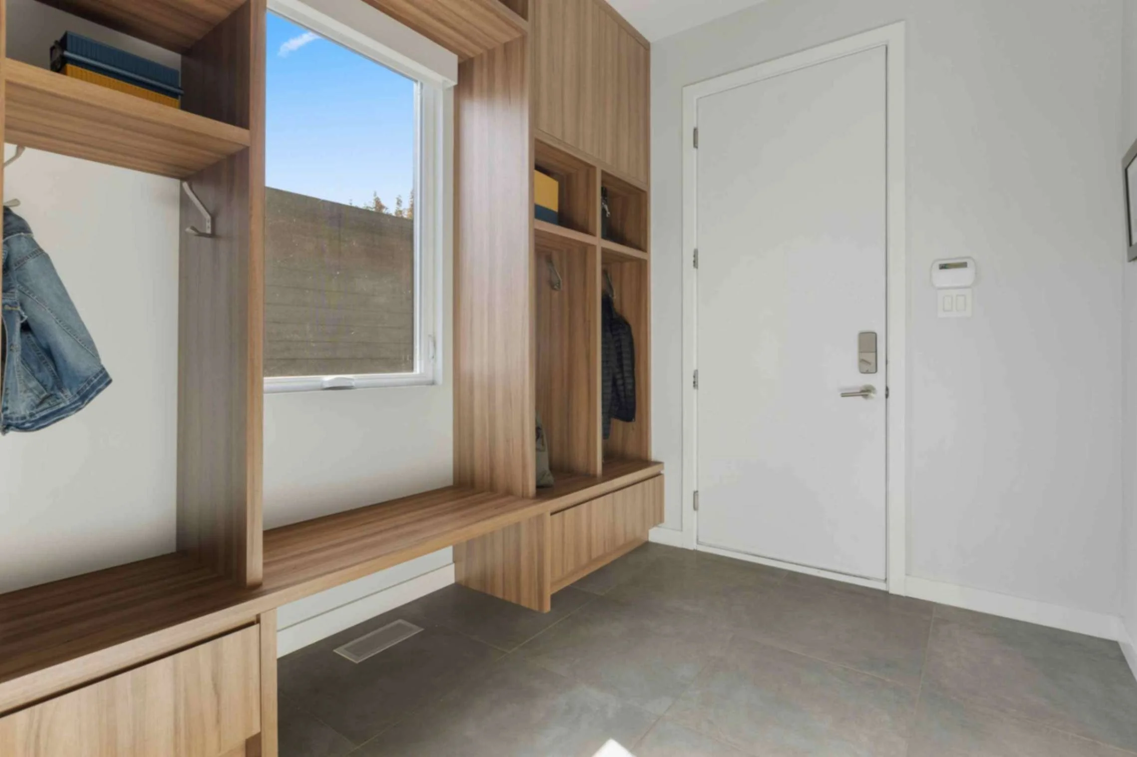 built in storage in mudroom with exterior door and window to outside with bench and shoe storage