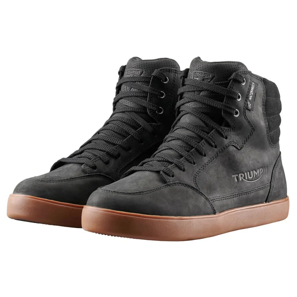 Svarta motorcykelstövlar med bruna sulor och logotypen "Triumph".