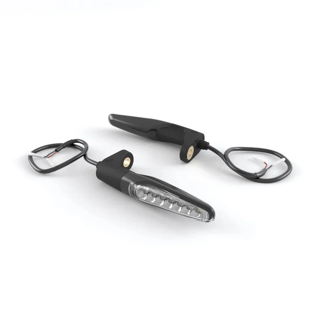 Två svarta motorcykelblinkers med kablar på en vit bakgrund.