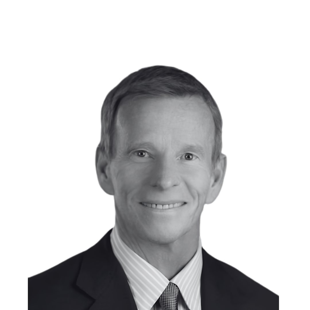 Black and white portrait of a smiling man wearing a suit and a striped tie, with a plain dark background.